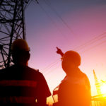 two worker watching the power tower and substation