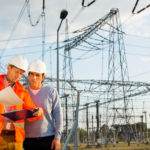 Male architects reviewing documents together at electric power plant