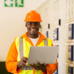 african electrical engineer with laptop computer in power plant