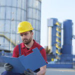 laborer outside a factory working dressed with safety overalls equipment