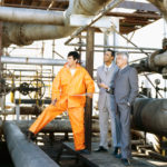 two male engineers and a mechanic standing in a power station